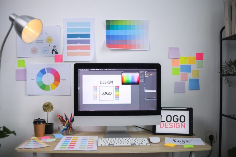 Graphic design workspace with logo design, color palettes, and creative branding materials for professional business marketing.